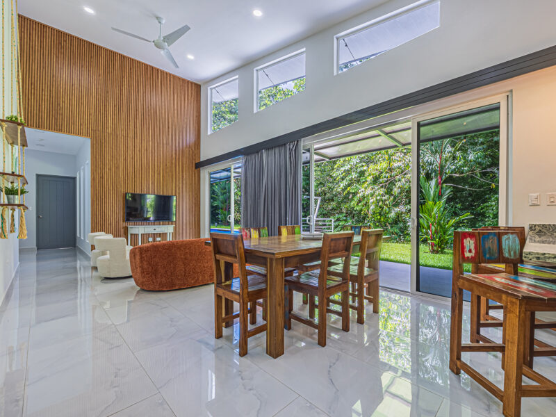 Residencia moderna de una planta con piscina privada, jardines tropicales y quebrada en Uvita.